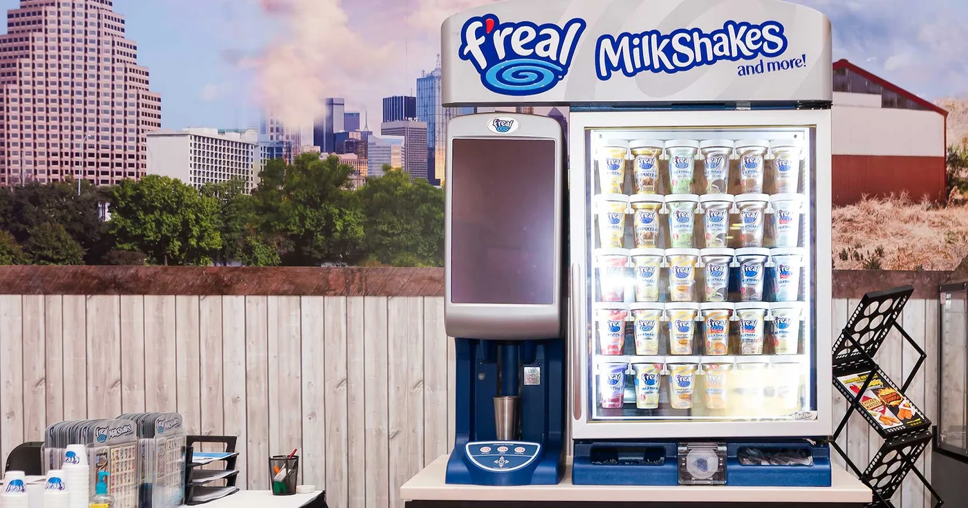 f'real milkshake station: freezer cabinet of cups beside the self-serve blender
