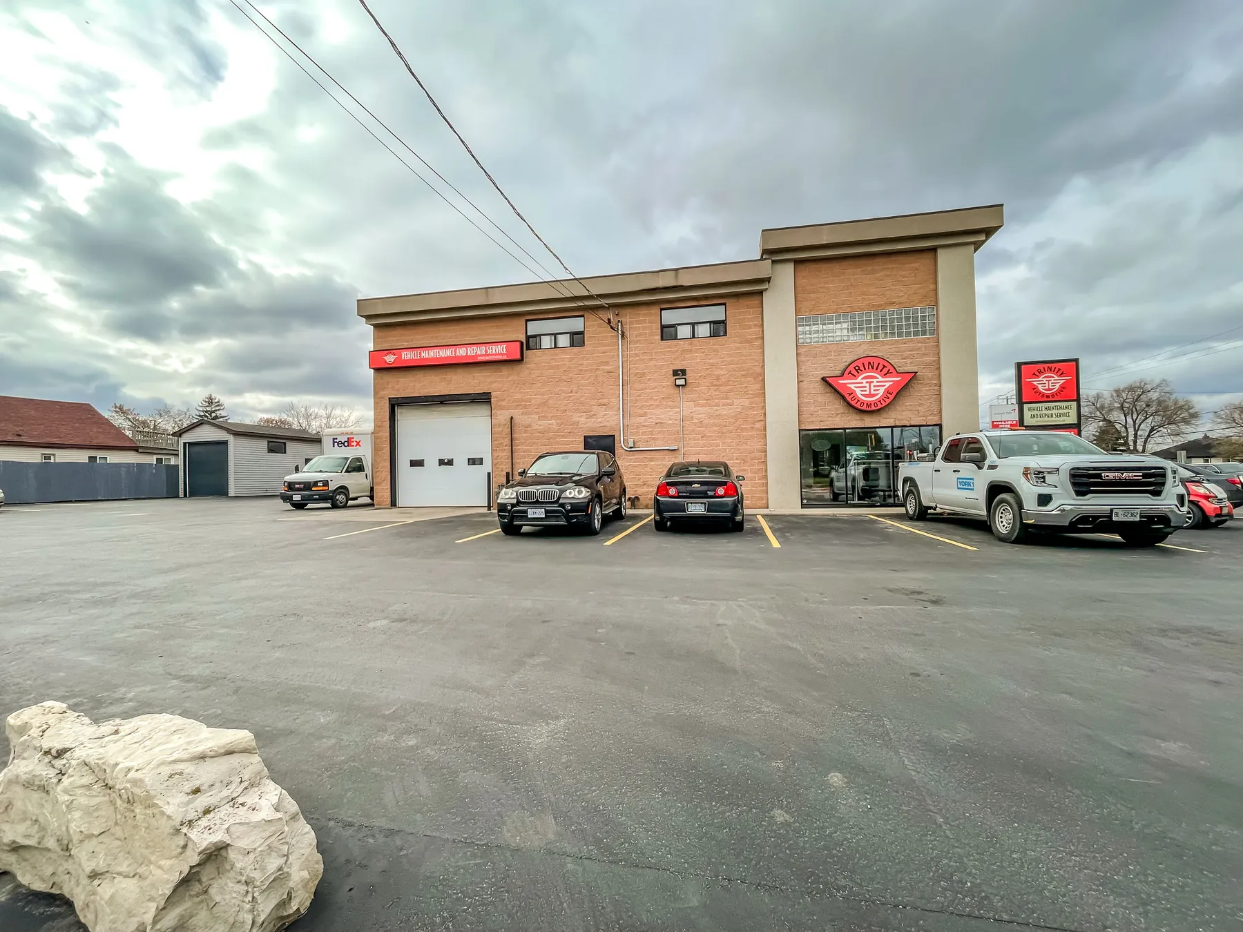 The building's blank south wall with vehicles parked against it
