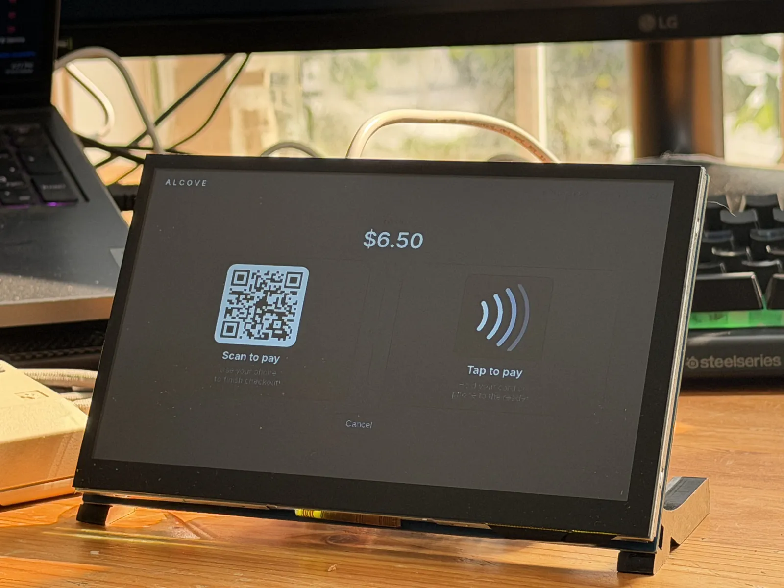 The checkout unit's payment screen: scan to pay with a QR code, or tap to pay