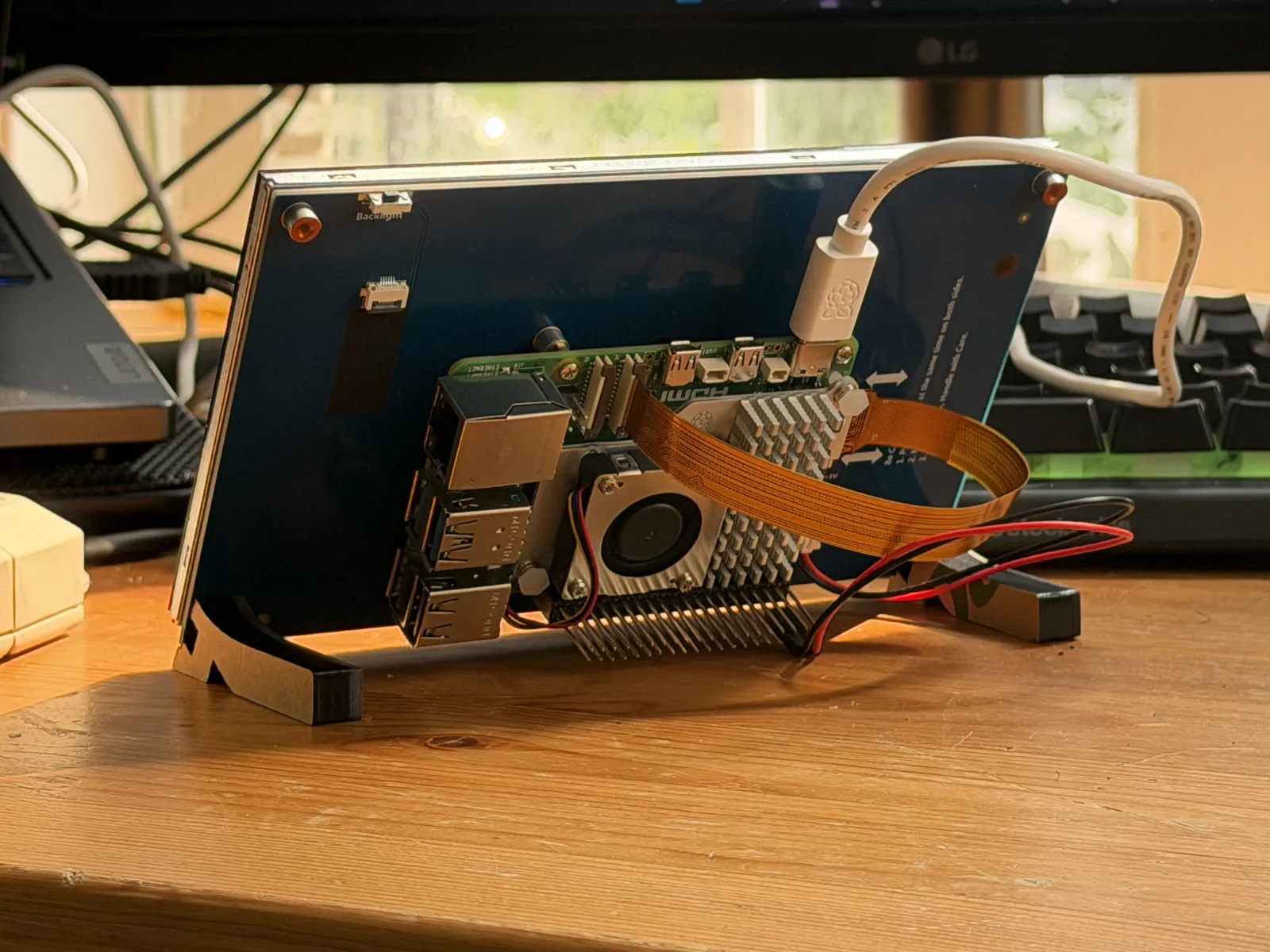 Rear of the checkout unit: the single-board computer, cooler, display ribbon, and lock-circuit leads on the header pins